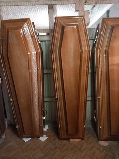 Cercueils en bois à panneaux sculptés, dressés côte à côte